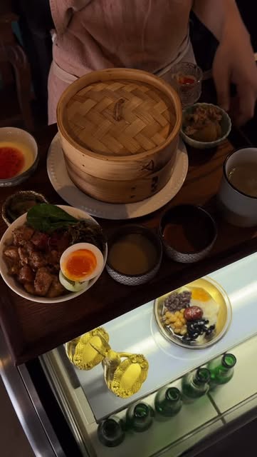 せいろと魯肉飯、豆花のデザートが並ぶお膳を運ぶ店主