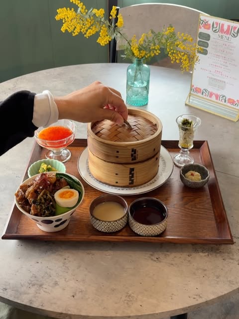 ミモザの花と、せいろの点心ランチ。竹のせいろに手が添えられている